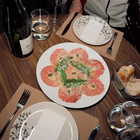 Carpaccio servido com garrafa de vinho branco Paul Mas